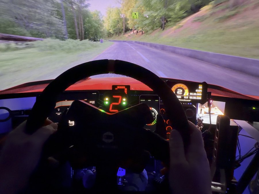 Driver's view on Adam's rig mid-stage, wheel in hand and gear 2 lit on the dashboard